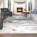 A Couristan Dreamscape Horizon blue and ivory area rug in a living room with a fireplace and a couch.