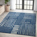 An Abani Casa Collection navy blue Southwestern area rug with white geometric patterns in a room.