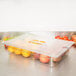 A Carlisle clear plastic food pan filled with fruit on a counter.