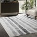 A faded striped gray and white Abani Casa Collection Moroccan area rug in a white room.