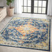 An Abani Casa Collection multicolor area rug with a traditional distressed floral design in blue and orange.