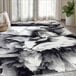 An Abani Arto Collection black and white liquid marble area rug in a room with a plant.