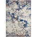A white area rug with blue and orange abstract spots.