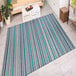 A Couristan Cape Brockton Cobalt / Teal area rug with blue and white stripes on the floor in a kitchen.