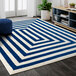 A navy and cream geometric area rug in a room.