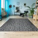 A Couristan Afuera Herringbone area rug in a room with a chair and a shelf.