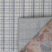 A close up of a Couristan area rug with a blue and white plaid pattern.
