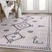 An Abani Molana Collection cream and gray area rug with a geometric design.