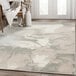 An Abani Arto Collection cream and gray area rug with a liquid marble design on a floor.