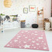 A pink Abani area rug with stars in a baby's room.