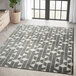 An Abani Casa Collection cream and gray area rug with geometric patterns in a room.