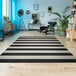 A Couristan Afuera Yacht Club onyx and ivory striped rug in a room with a chair and plant.