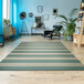 A room with a blue and green striped Couristan Afuera Yacht Club area rug and a chair.