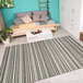 A room with a blue and white striped Couristan Cape Brockton area rug.