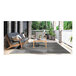 A table and chairs on a Couristan area rug on a patio.
