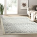 An Abani Cabo Collection gray geometric area rug on a wood floor.