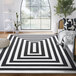 A cream and black rectangular area rug with a geometric stripe design.