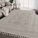 An Abani Layla Collection beige and brown area rug with tassels on the floor.