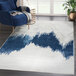 A blue and gray abstract mountain area rug in a room.