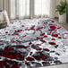 A gray and red Abani Arto Collection area rug with a white and black pattern in a room.