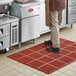 A man standing on a red Lavex heavy-duty anti-fatigue floor mat.