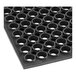 A close up of a black rubber Lavex anti-fatigue floor mat with holes in it.