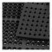 A close-up of a Lavex black rubber anti-fatigue floor mat with holes in it.