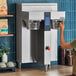 A woman using a Fetco commercial coffee maker.