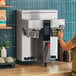 A woman using a Fetco CBS-2232 coffee machine.