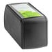 A black rectangular Tork Xpressnap countertop napkin dispenser with a green label.