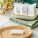 A Grey + Finch Crisp Air bar of soap on a plate next to white paper bags.