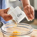 A person using the Choice Rotary Grater to shred cheese over a bowl.