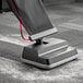 A Hoover Superior Lite upright vacuum cleaner with a red cord on a grey carpet.