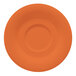 A white saucer with a circle in the middle and an orange pumpkin design.