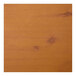 A close-up of a Perfect Tables 24" round knotty pine table top with a brown stain.