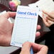 A hand holding a green and white Choice guest check with a top receipt.