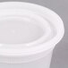 A close-up of a Pactiv translucent round squat deli container with a lid.