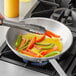 A person cooking Bunge Country Premium Liquid Margarine with vegetables in a skillet.