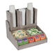 A Cal-Mil wooden condiment organizer on a counter with cups and tea bags inside.