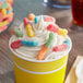 A cup of ice cream with Trolli Sour Brite Gummy Worms on top.