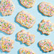 A cookie with white frosting and colorful Adourne Mini Pastel Confetti Sequin Sprinkles.