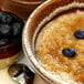 A bowl of oatmeal with brown sugar and blueberries.
