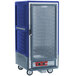 A blue Metro C5 heated holding cabinet with a clear door on wheels.