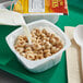 A bowl of Honey Nut Cheerios cereal with milk being poured into it.