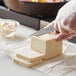 A person slicing a block of ForA plant-based vegan butter with a knife.