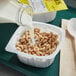 A person pouring milk into a bowl of Cheerios.
