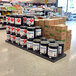 A black Benchmaster plastic platform panel on a grocery store aisle counter.