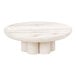 A Cal-Mil white-washed pine wood round display riser on a white round table.