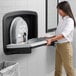 A woman using a Koala Kare stainless steel baby changing station.