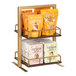 A Cal-Mil gold metal display rack with oak wood shelves holding bags of almonds and popcorn.